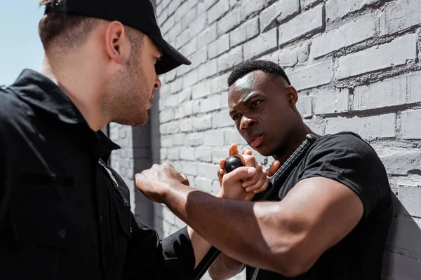 Foco seletivo do policial detendo emocional homem americano africano, conceito de racismo — Fotografia de Stock