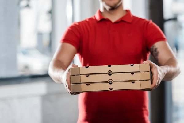Vista recortada del repartidor hombre sosteniendo cajas de pizza - foto de stock