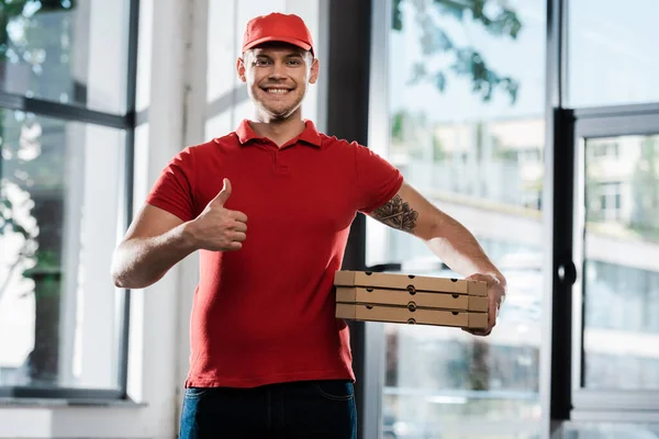 Homem de entrega feliz mostrando polegar para cima e segurando caixas de pizza — Fotografia de Stock