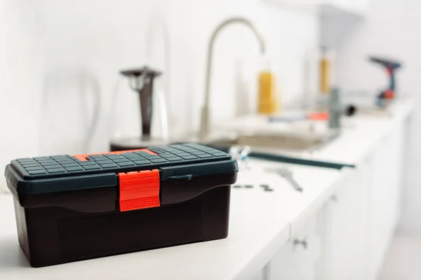 Focus selettivo della cassetta degli attrezzi sul piano di lavoro in cucina — Foto stock