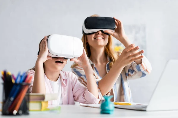 Selective focus of excited kid using vr headset near mother during online education — Stock Photo