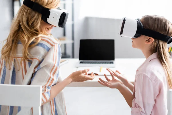 Donna sorridente utilizzando auricolari vr con figlia a casa — Foto stock