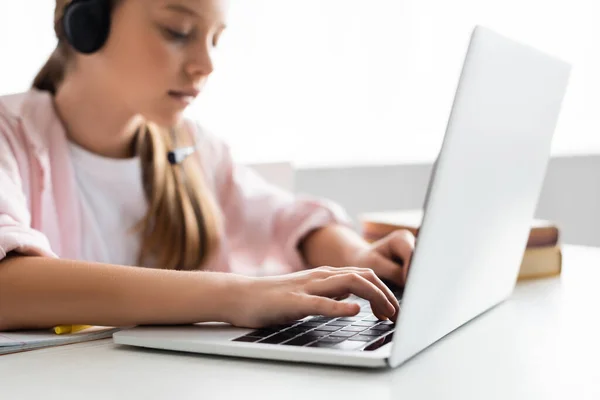 Selektiver Fokus des Kindes beim Tippen im Headset auf dem Laptop zu Hause — Stockfoto