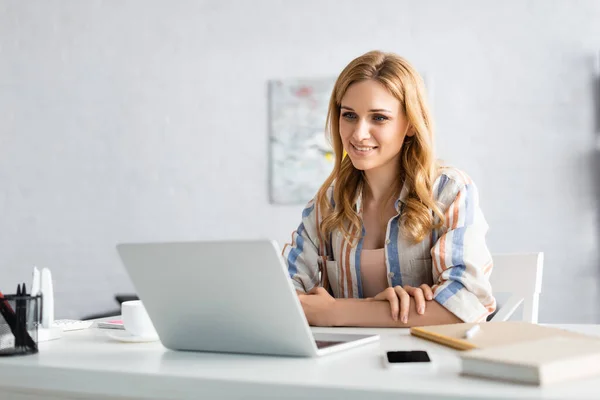 Selective focus of attractive freelancer working with laptop — Stock Photo