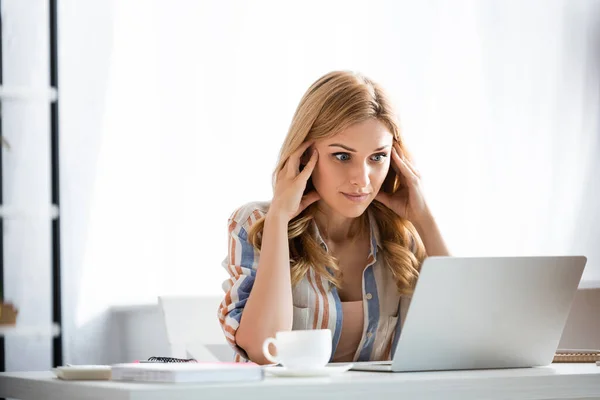 Selective focus of pensive woman looking at laptop — Stock Photo