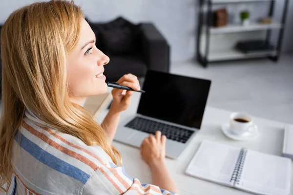 Selektiver Fokus einer lächelnden Frau bei der Arbeit mit dem Laptop — Stockfoto