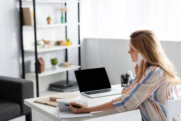 Selective focus of pretty woman working with laptop and digital device — Stock Photo