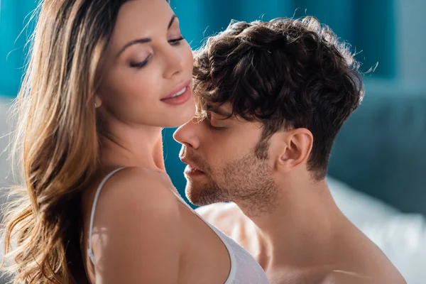 Selective focus of shirtless man kissing in neck beautiful smiling girlfriend — Stock Photo