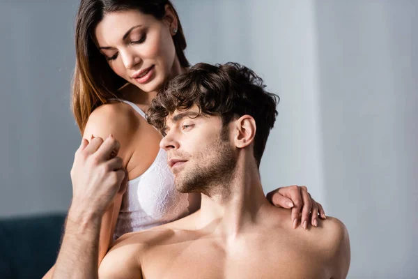 Hombre sin camisa cogido de la mano de mujer hermosa - foto de stock