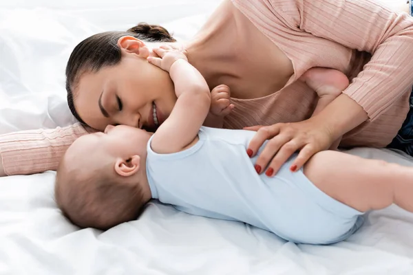 Mutter mit geschlossenen Augen mit Baby im Bett liegend — Stockfoto