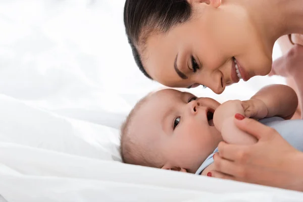 Mère souriante regardant le fils bébé dans la chambre — Photo de stock