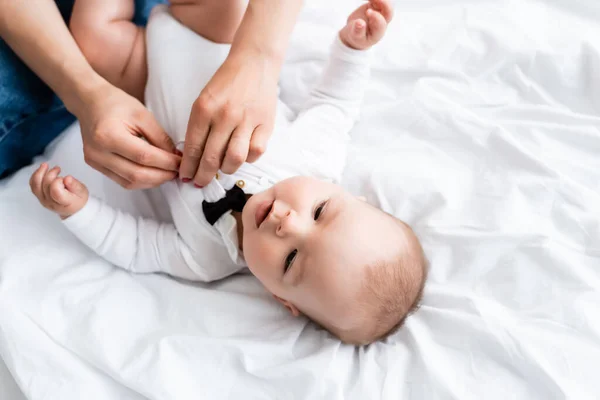 Overhead view of woman wearing baby romper on infant son — Stock Photo