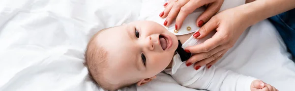 Intestazione del sito web di donna che indossa pagliaccetto bambino sul figlio neonato — Foto stock