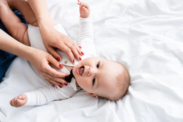 Vista superior de la mujer con bebé mameluco en el hijo bebé - foto de stock