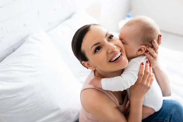 Vista aérea de mujer feliz sosteniendo en brazos adorable bebé niño - foto de stock