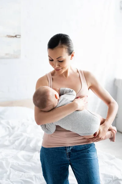 Happy mother breastfeeding baby boy in bedroom — Stock Photo