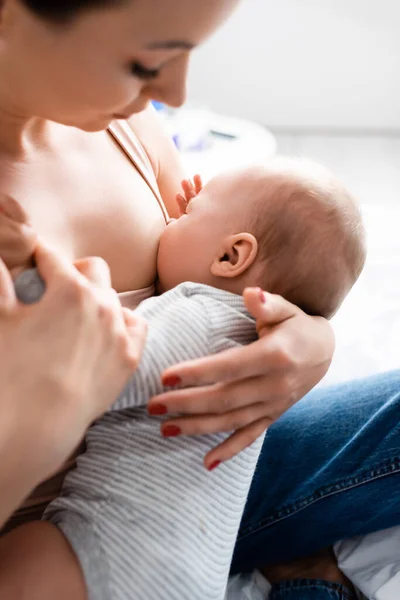 Selective focus of woman breastfeeding baby boy — Stock Photo