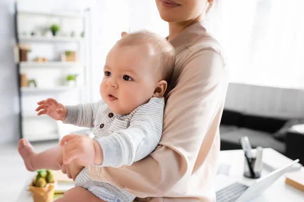 Mother holding in arms adorable infant son at home — Stock Photo