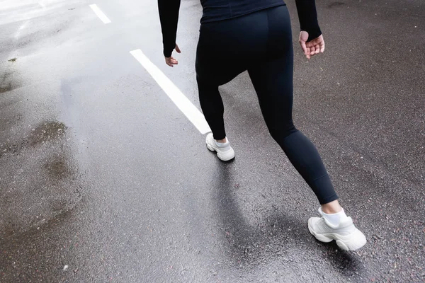Обрізаний вид дівчини в білих кросівках, що бігають надворі — стокове фото