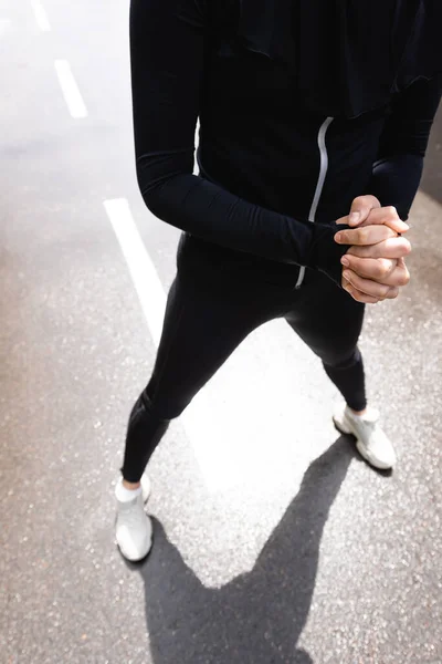 Cropped view of sportswoman with clenched hands exercising outside — Stock Photo