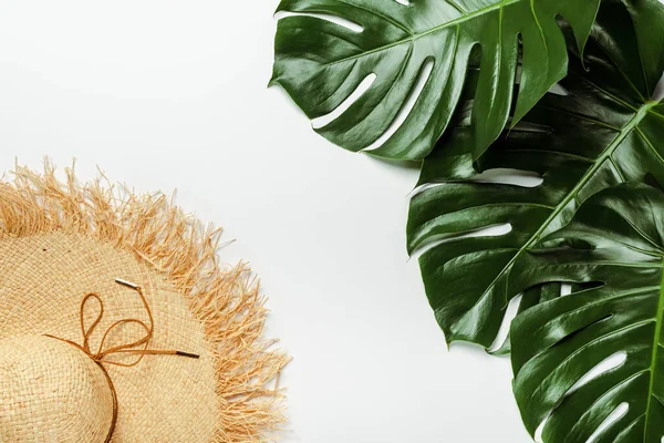 Top view of green palm leaves, straw hat on white background — Stock Photo