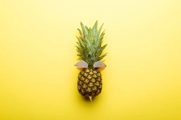 Vista superior de la piña madura en gafas de sol sobre fondo amarillo - foto de stock