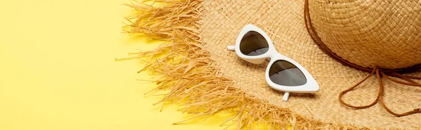 Straw hat and stylish suglasses on yellow background, panoramic shot — Stock Photo