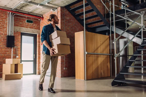 Empresário segurando caixas e andando em escritório novo e moderno — Fotografia de Stock
