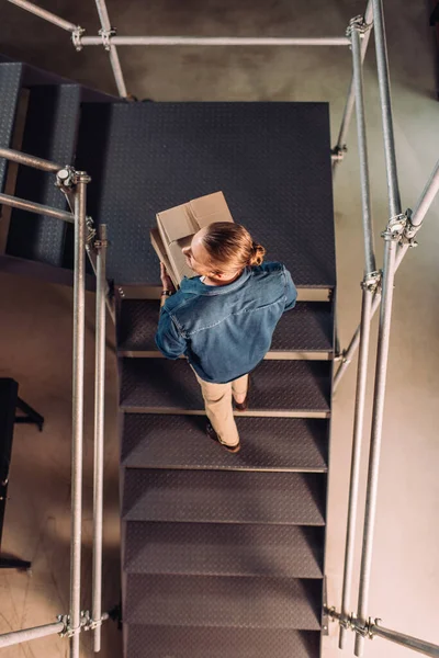 Top view of businessman holding boxes and walking on stairs in new office — Stock Photo