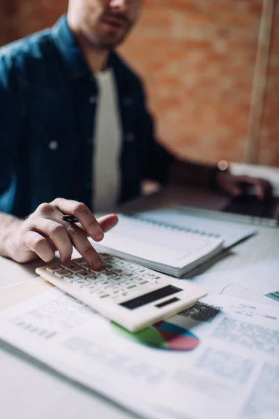 Selective focus of businessman using calculator near notebook — Stock Photo