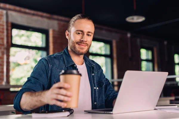 Selektiver Fokus glücklicher Geschäftsleute, die Pappbecher neben Laptop halten — Stockfoto