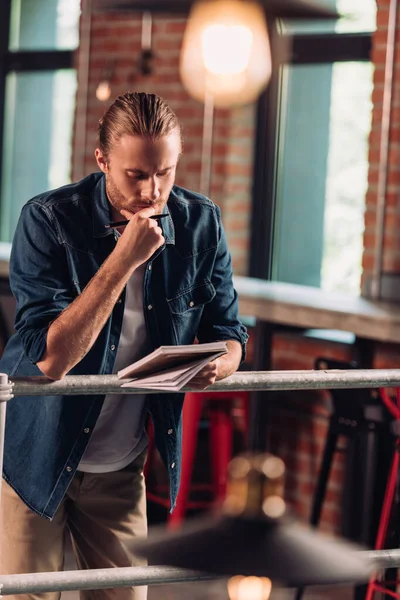 Enfoque selectivo de empresario pensativo que sostiene la pluma y mirando el cuaderno en la oficina moderna - foto de stock