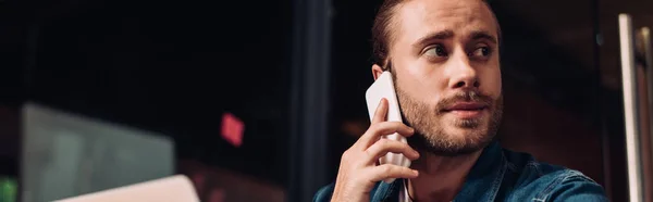 Panoramic crop of businessman looking away and talking on smartphone — Stock Photo