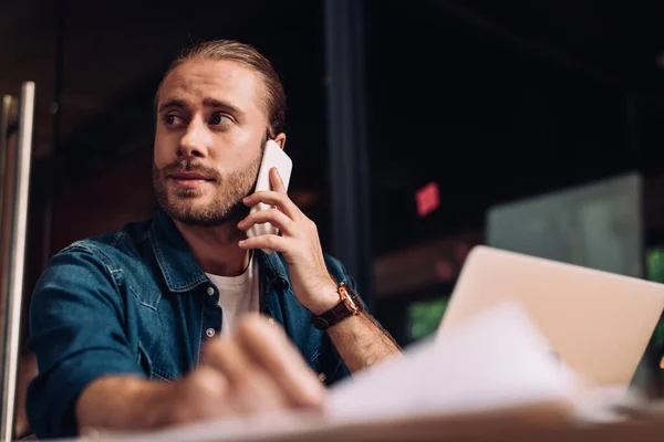 Selektiver Fokus des Geschäftsmannes, der wegschaut und auf dem Smartphone spricht — Stockfoto