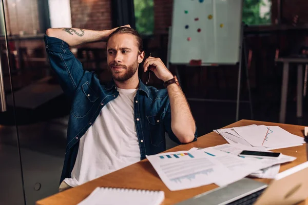 Enfoque selectivo de empresario feliz celebración de pluma cerca de gadgets, gráficos y gráficos en el escritorio - foto de stock