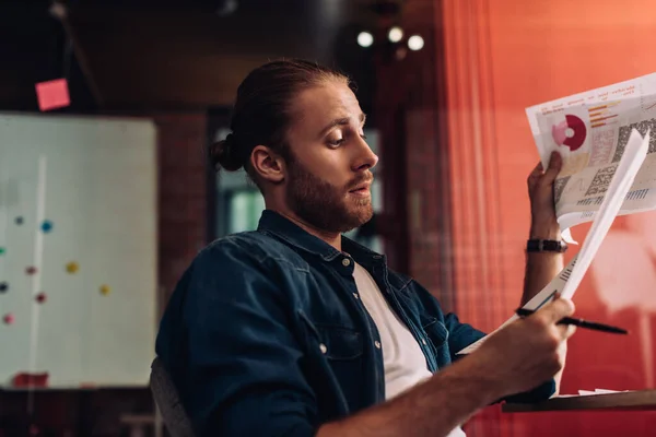 Messa a fuoco selettiva di uomo d'affari barbuto guardando grafici e grafici — Foto stock