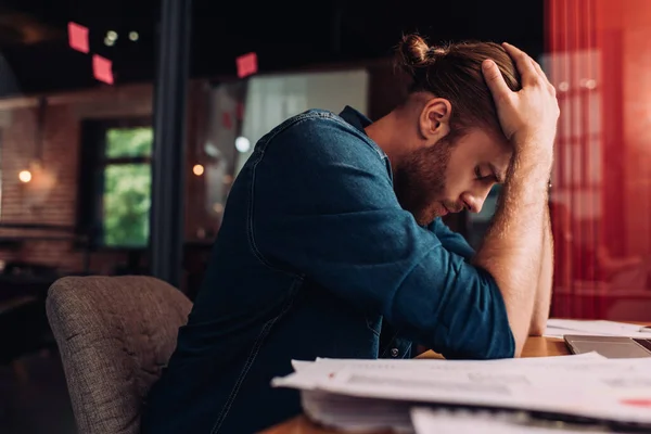 Selektiver Fokus eines verärgerten Geschäftsmannes, der im Büro am Schreibtisch sitzt — Stockfoto