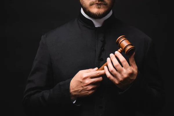 Cropped view of bearded priest holding wooden gavel isolated on black — Stock Photo