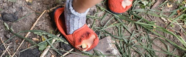 Панорамний урожай бідної дитини, що стоїть в рваному взутті — стокове фото
