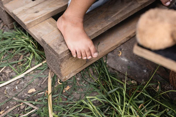 Cropped view of barefoot and poor kid walking outside — Stock Photo