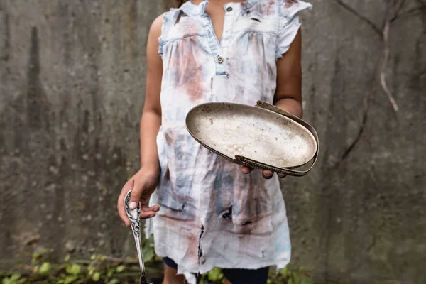 Cropped view of poor african american child holding dirty metal plate while begging alms on urban street — Stock Photo