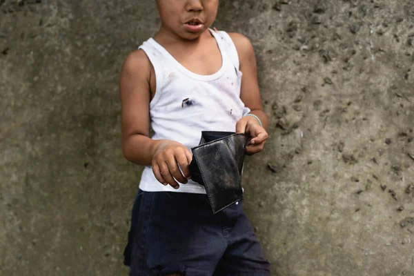 Vista cortada da criança afro-americana pobre em roupas bagunçadas segurando carteira na rua urbana — Fotografia de Stock