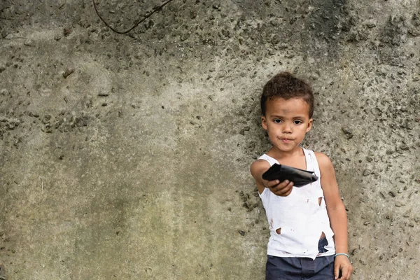Focus selettivo del povero ragazzo afroamericano mostrando portafoglio vicino al muro di cemento sulla strada urbana — Foto stock