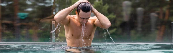 Concepto panorámico de hombre húmedo y muscular tocando el cabello en la piscina — Stock Photo