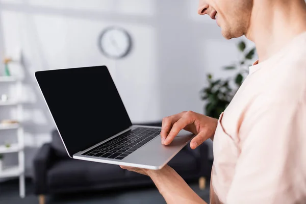 Cropped view of smiling freelancer holding and using laptop at home, earning online concept — Stock Photo