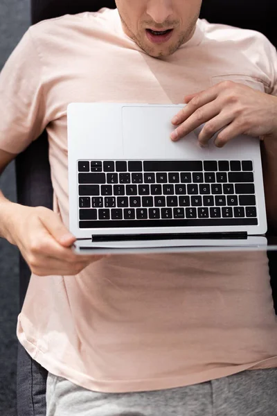 Vista dall'alto di un freelance scioccato che utilizza laptop sul divano, guadagnando concetto online — Foto stock