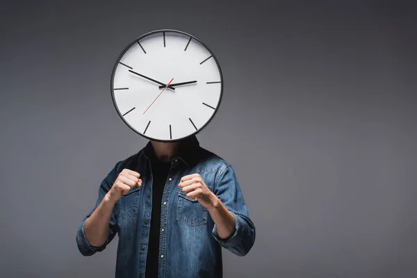 Man with clock on head and clenched fists on grey background, concept of time management — Stock Photo