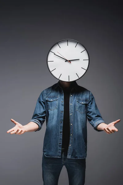 Homme avec horloge sur la tête pointant avec les mains sur fond gris, concept de gestion du temps — Photo de stock