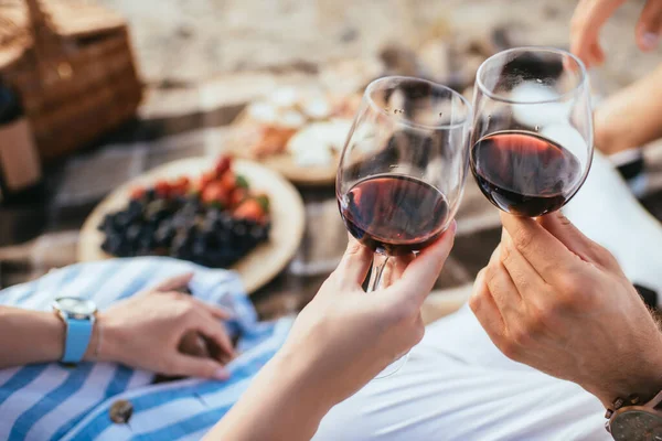 Foco seletivo de homem e mulher copos clinking com vinho tinto — Fotografia de Stock