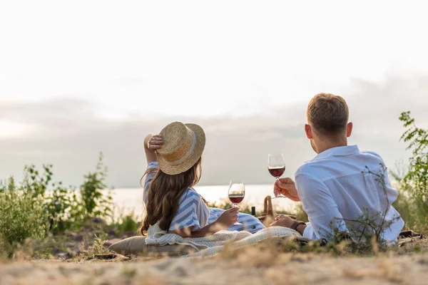 Back view of couple holding glasses with red wine outside — Stock Photo